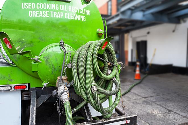 worker pumping grease trap at commercial kitchen in Bellevue IA